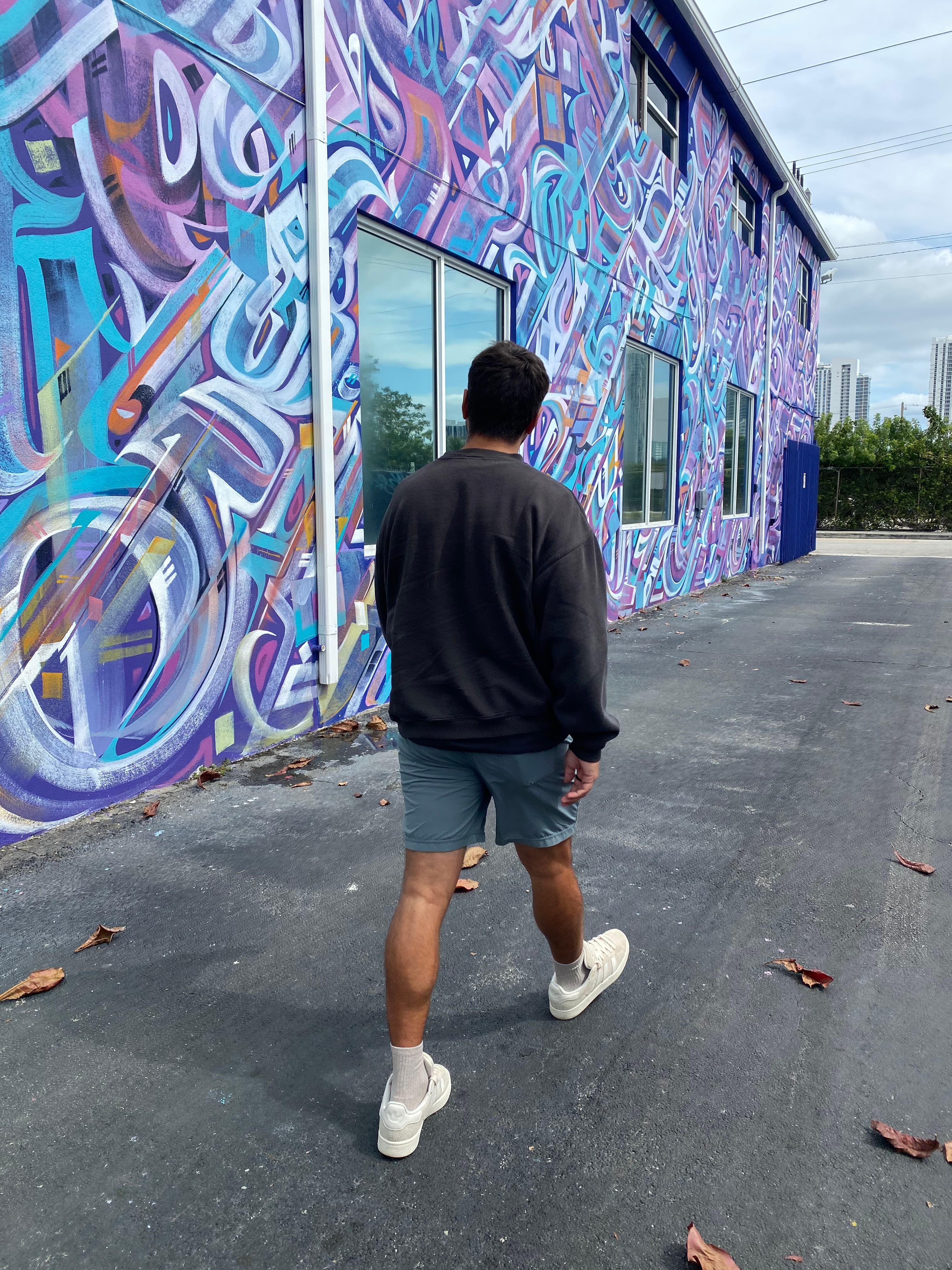 Austin walking past a colorful painted mural
